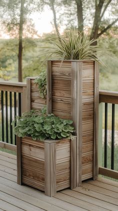 three wooden planters with plants in them on a deck