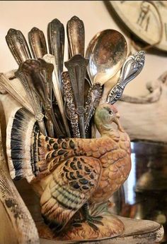 a turkey figurine with spoons and forks in it's beak holder