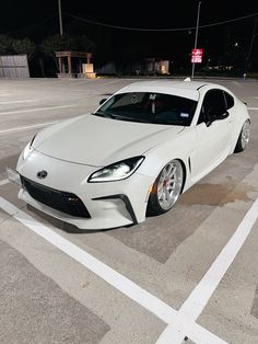 a white sports car parked in a parking lot