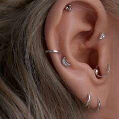 an ear with three piercings on top of it, and one behind the ear