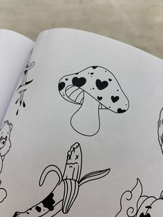 an open book with black and white drawings on it's cover, featuring cartoon characters