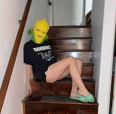 a woman sitting on top of a wooden stair case