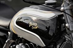 a close up view of the front end of a black and silver motorcycle with gold lettering