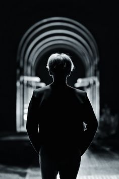 a man standing in front of a tunnel with his back to the camera