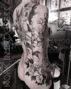 the back of a woman's body with flowers on it