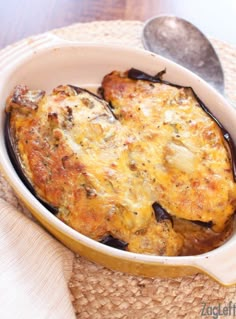 an eggplant casserole in a dish with a spoon on the side