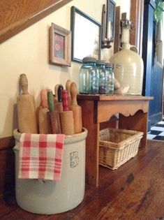 an old country home's postcard is displayed on the wall next to a basket with kitchen utensils in it