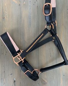 a black bridle with rose gold hardwares on the sides and pink accents