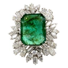 Vintage emerald with diamonds ring, circa 1970's. Approximately 14.10ct emerald apx F2 surrounded by apx 5.35ct of round, marquise, and baguette diamonds. Apx 19.45ct total gemstone weight, set in 18k white gold. Accommodated with an up to date appraisal by a GIA G.G. upon request. please contact us with any questions. Item Number R8214 Emerald = Approximately 14.10ct Marquise, Baguette, and Round Diamonds = Approximately 5.35ct, G/H color and VS/SI clarity Total Gemstone Weight = Approximately Weight Set, Gold Cocktail Ring, Vintage Diamond Rings, Gold Cocktail, Baguette Diamonds, Diamonds Ring, White Gold Diamond Rings, Diamond Cluster Ring, Gold Diamond Rings