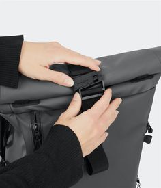 a person is holding onto a gray bag