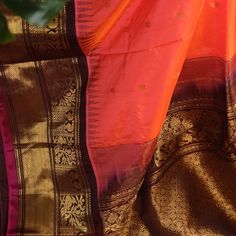 Vibrant as a sunset sky, the sunset orange Gadwal silk saree dazzles with warmth, all-over woven zari polkas shimmering like playful sparks. Gold zari woven maroon border and pallu gleam like molten lava, while the embroidered maroon blouse adds a touch of fiery elegance. Together, they create a canvas of vibrant energy, a celebration of life's fiery passion. She who wears this saree is a fiery spirit, her beauty and grace as radiant as a sunset, her heart as warm as the golden light that fades into twilight * Gadwal silk saree for special occasions. * Crafted from the premium quality fabric. * Supplied with a readymade blouse. * The blouse comes with an added allowance, and it can be altered to a standard size of 34"-42" on request. * Dry clean only to maintain colour and quality.  Note: Orange Bollywood Cotton Silk Saree, Orange Bollywood Style Cotton Silk Saree, Festive Orange Katan Silk Saree, Orange Cotton Silk Saree With Dupatta, Bollywood Style Orange Cotton Silk Saree, Orange Handloom Pre-draped Saree, Diwali Orange Tussar Silk Pre-draped Saree, Bollywood Style Orange Handloom Pre-draped Saree, Orange Handloom Pre-draped Saree For Diwali