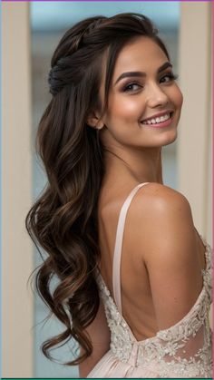 a woman with long hair wearing a white dress and smiling at the camera while standing in front of a doorway