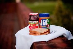 peanut butter and jelly sandwich sitting on a white cloth next to a bottle of juice