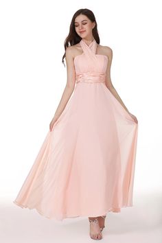 a woman in a long pink dress with a halt neckline and pleaed skirt