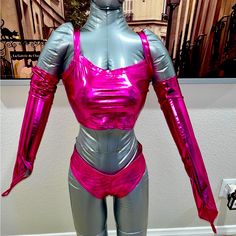 a mannequin is dressed in shiny silver and pink clothing with an open back