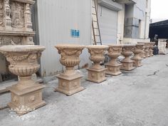 several stone urns are lined up in front of a building