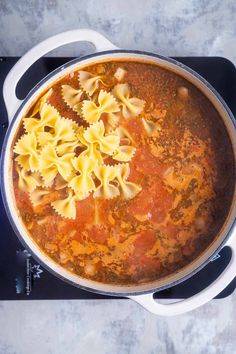 a pot filled with pasta and sauce on top of a stove