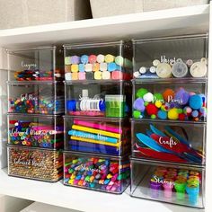 plastic storage bins filled with craft supplies on top of a white shelf in a room