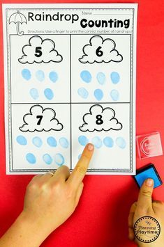 a hand is pointing at the numbers that are on top of a counting game for kids