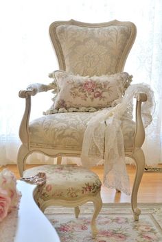 a chair and foot stool in front of a window