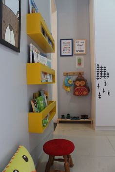 a child's room with yellow shelving and bookshelves on the wall