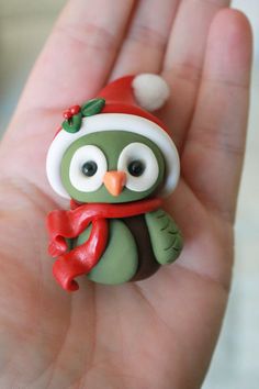 a small green and white owl wearing a santa hat