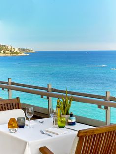 two chairs and a table on a balcony overlooking the ocean