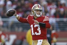 a close up of a football player holding a ball in the air with one hand