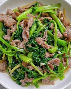 a white bowl filled with meat and vegetables