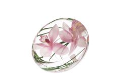 some pink flowers are in a clear glass ball on a white surface with green stems