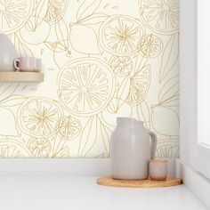 a white vase sitting on top of a counter next to a wallpapered wall