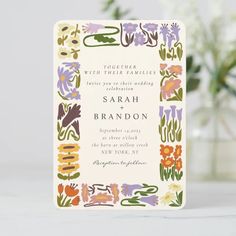 the wedding card is decorated with colorful flowers