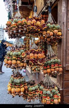 an outdoor market with lots of hanging fruit and vegetables for sale on the side of the road