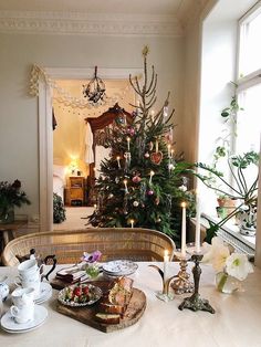 a christmas tree is in the middle of a table with plates and cups on it