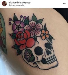 a woman's thigh with a skull and flowers on it