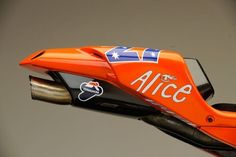 an orange motorcycle with the name alice written on it's side and silver handlebars