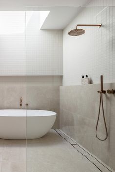 a white bath tub sitting in a bathroom next to a shower head and faucet