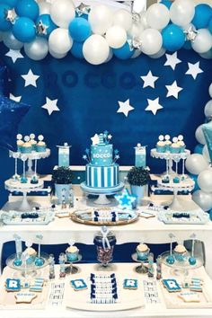 a blue and white dessert table with balloons