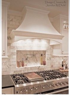 a stove top oven sitting inside of a kitchen next to white cabinets and counter tops