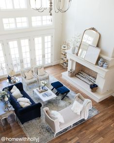 a living room filled with lots of furniture and a chandelier hanging from the ceiling