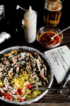 a pizza sitting on top of a pan covered in toppings next to a notebook