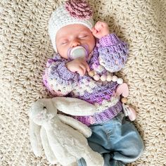 a baby is sleeping with a pacifier in it's mouth next to a stuffed animal