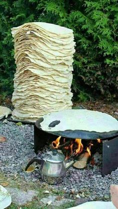 an outdoor fire pit with stacks of paper stacked on top