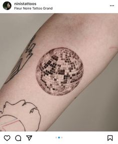 a person with a tattoo on their arm that has an image of a disco ball