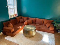 a living room filled with furniture and a large round coffee table in front of a window