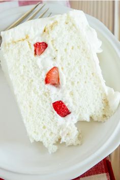 a slice of white cake with strawberries on it and a fork in the middle