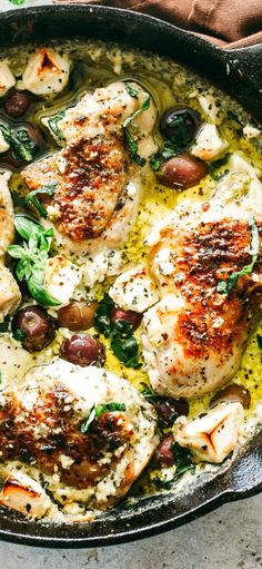 chicken with olives and spinach in a cast iron skillet