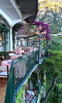 an outdoor dining area with tables and chairs on the balcony, overlooking a scenic valley