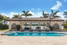 an outdoor pool with lounge chairs next to it