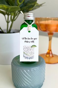 a bottle of alcohol sitting on top of a table next to a glass and potted plant